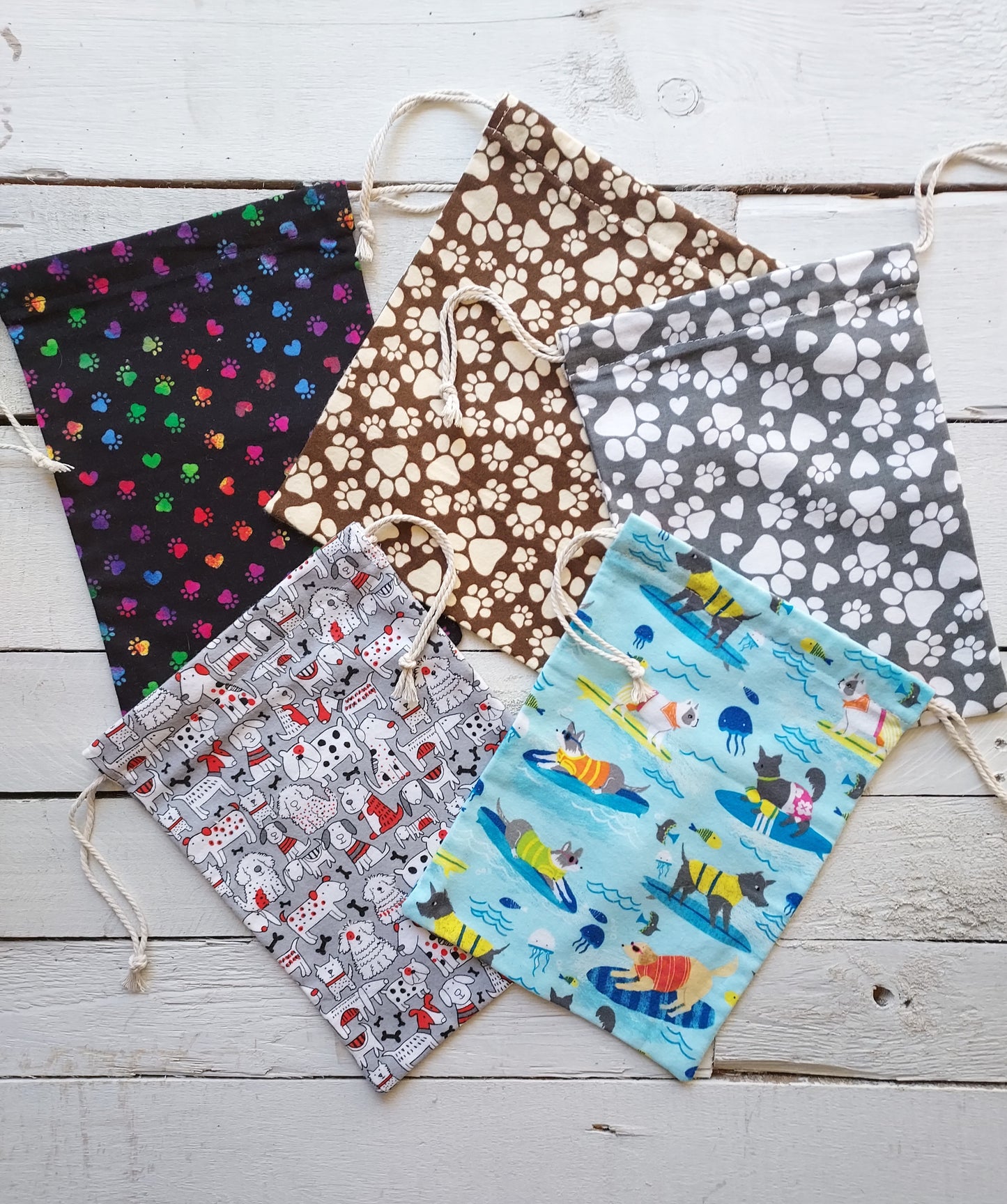 Drawstring gifts bags with various patterns on a wooden surface
