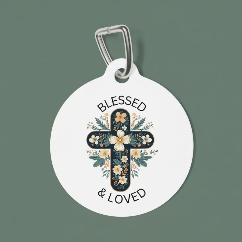 Round white dog tag with floral cross design and 'Blessed & Loved' text on a white background
