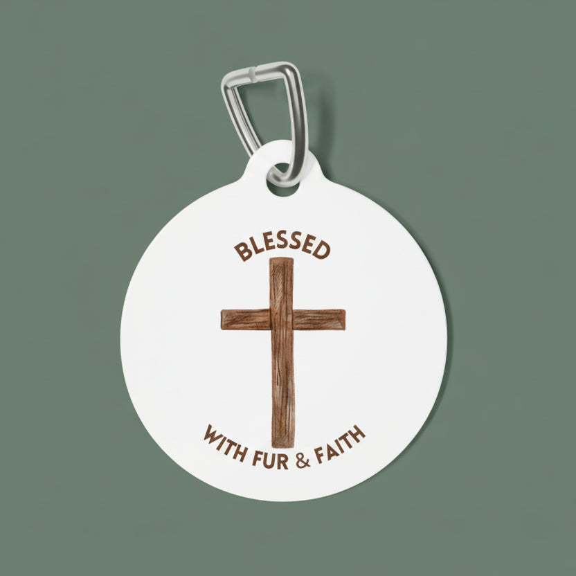 Round pet tag with wooden cross and text 'Blessed with fur & faith' on a white background