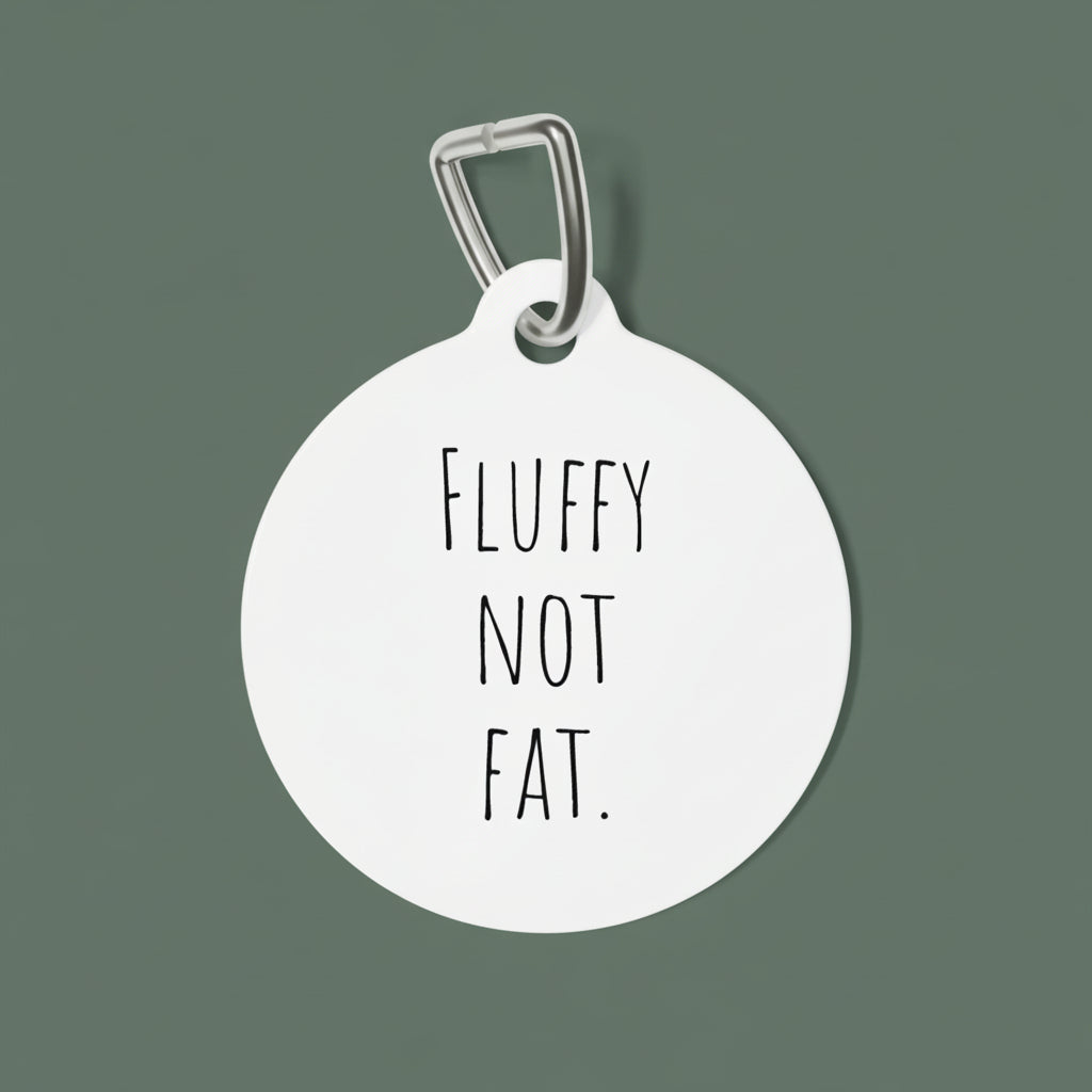 Round white pet tag with 'Fluffy Not Fat' text on a white background