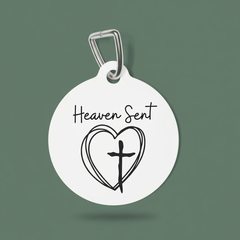 Round dog tag with 'Heaven Sent' text and heart with cross design on a white background
