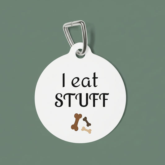 Round white pet tag with 'I eat STUFF' text and dog bone illustrations on a white background