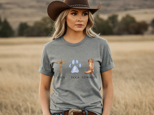 Woman wearing a gray t-shirt with religious and cowboy-themed graphics in a field.