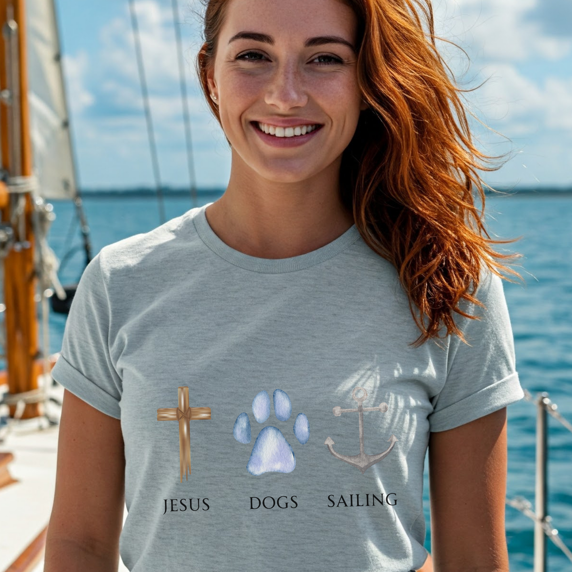 Woman on a sailboat wearing a t-shirt with religious, dog, and nautical symbols and text.
