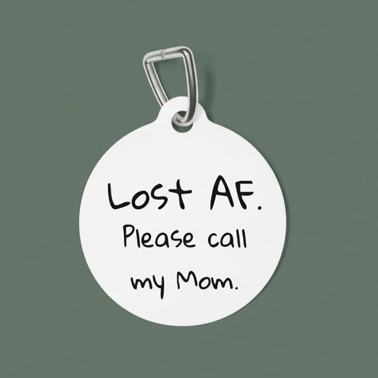 Round dog tag with black text 'Lost AF. Please call my Mom.' on a white background