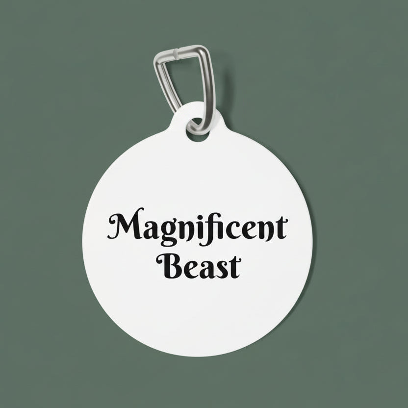 Round white dog tag with 'Magnificent Beast' text on a white background