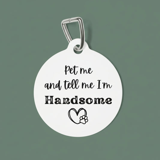 White pet tag with black text and paw print on a white background
