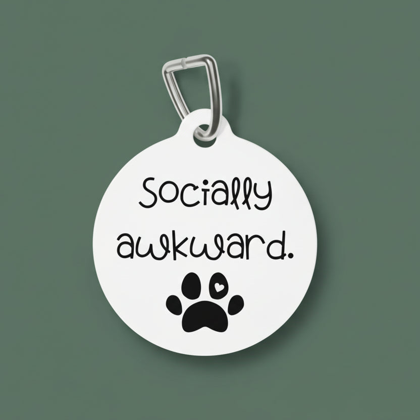 Round white pet tag with 'Socially awkward.' text and paw print design on a white background