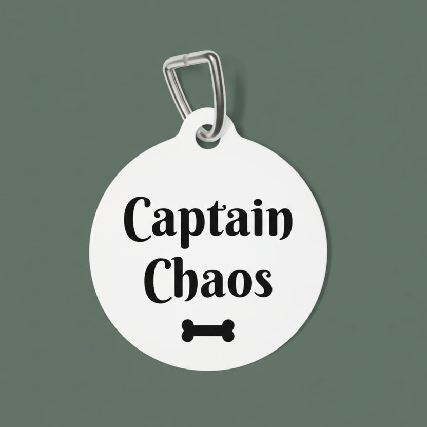 Round white pet tag with 'Captain Chaos' text and bone icon on a white background