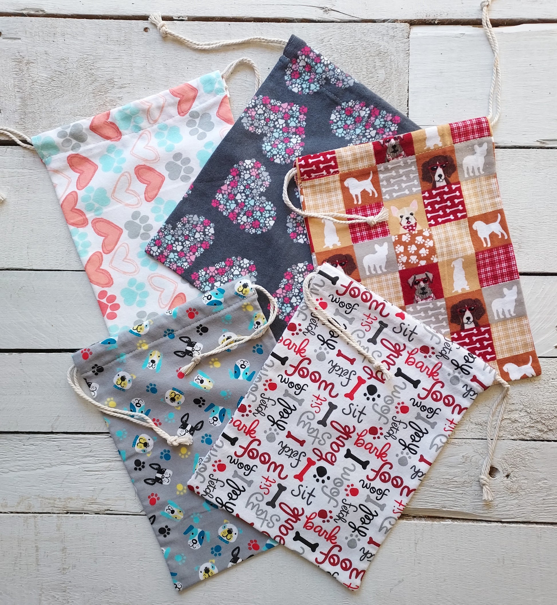 Flannel fabric gift bags with various patterns on a wooden surface