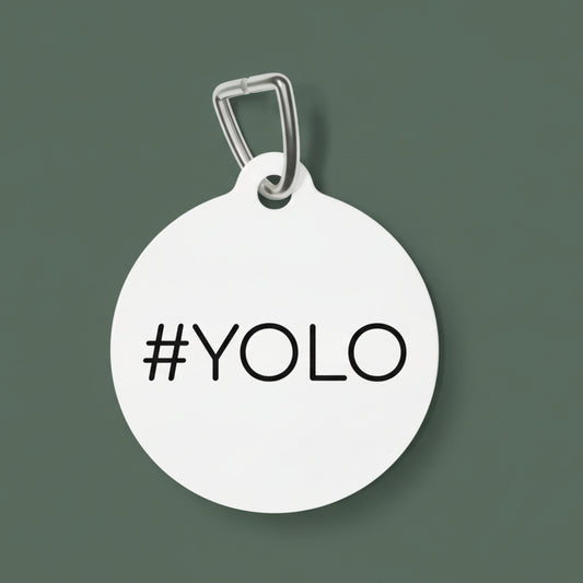 Round white dog tag with '#YOLO' text on a white background